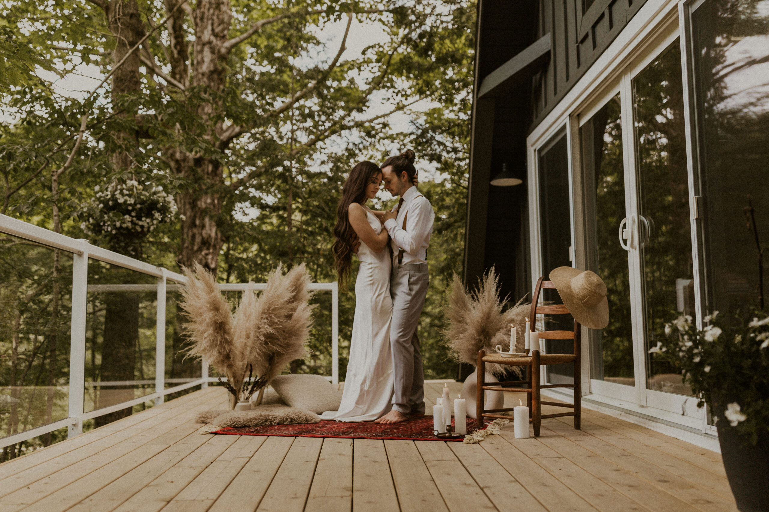 Couple embracing during their elopement ceremony, outside of their A-frame cabin in the forest in southern Ontario.