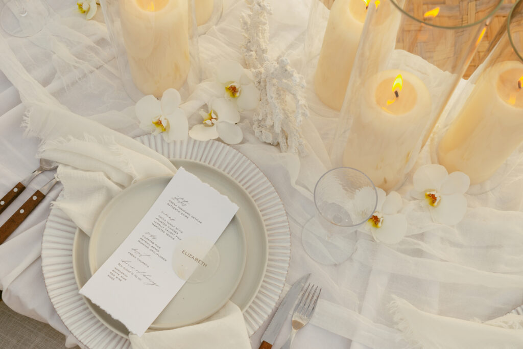 Photograph of a Tablescape with coral, candles and florals all in cream and white. Elope in Toronto