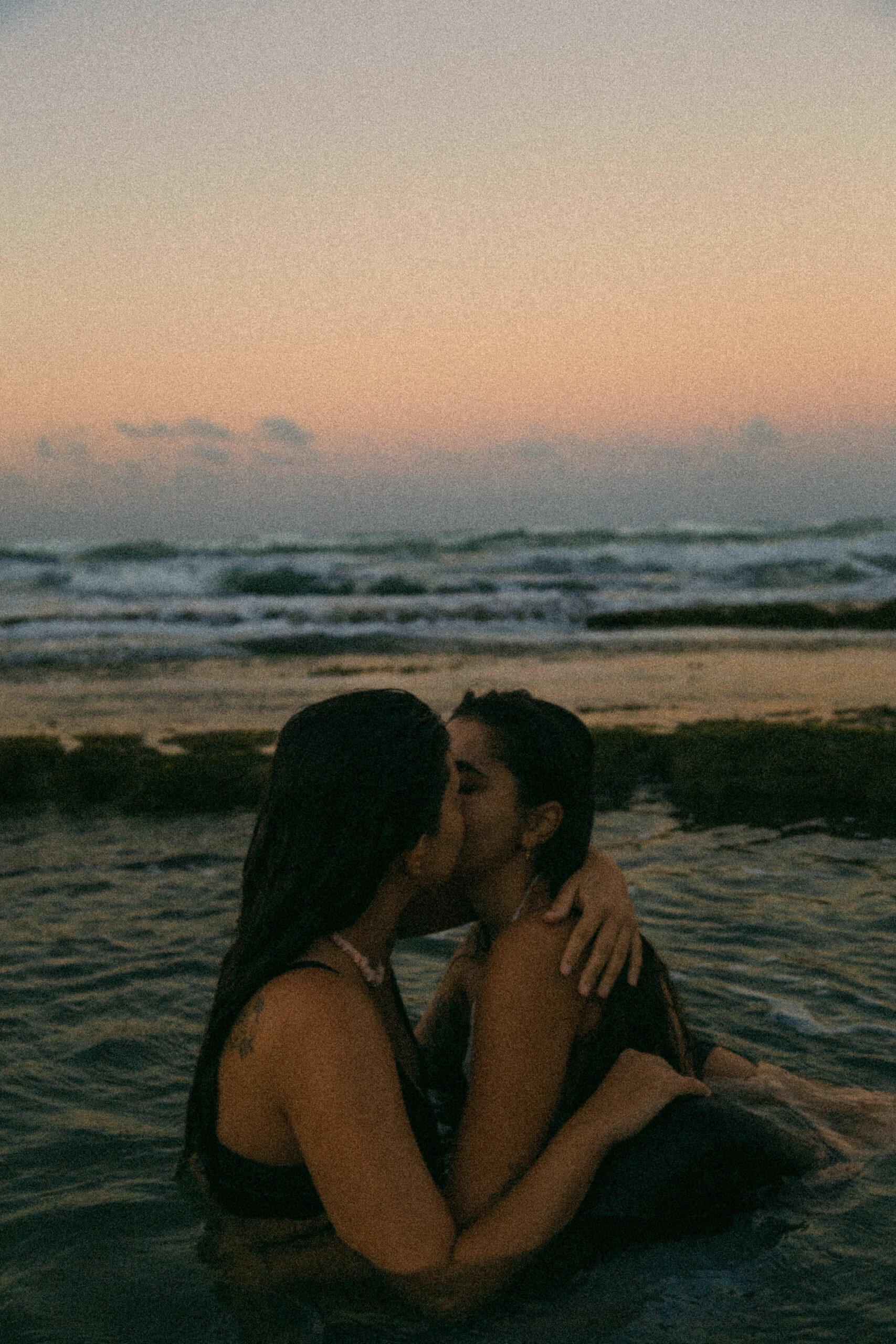 Couple Floating in the tidal pools during at sunset during their beach engagement session in Dominican Republic.